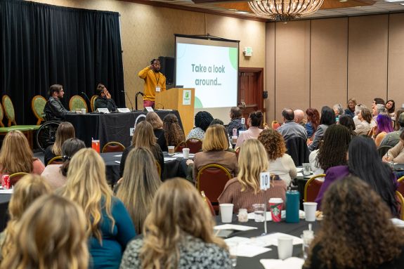 A man speaks at a podium during a conference