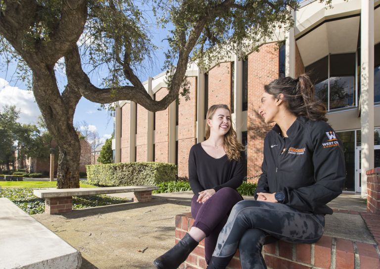 two students sitting on campus