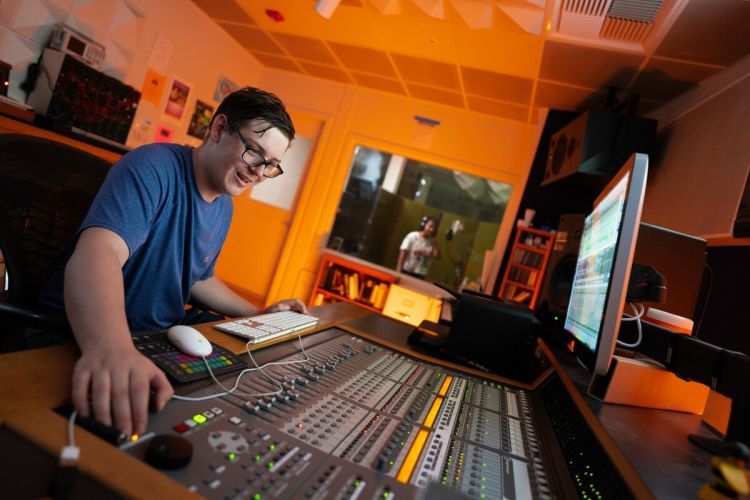 a student sits in a recording booth