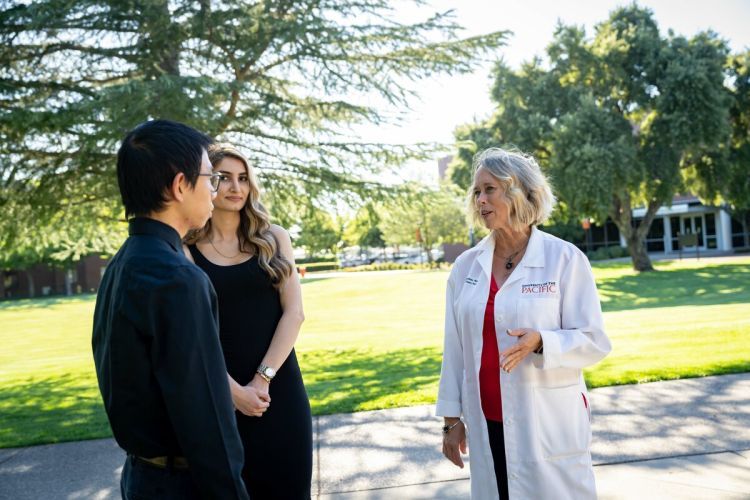 Berit Gundersen speaks with two students