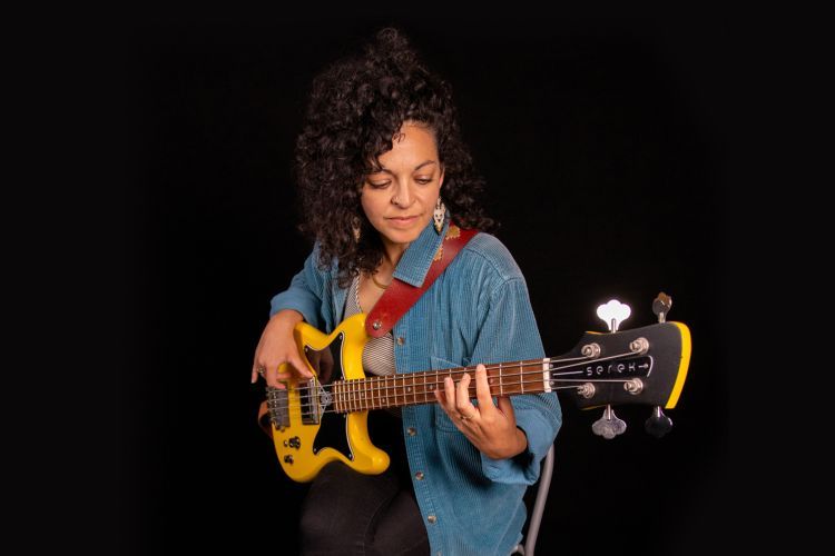 Suazanne Galal playing bass guitar.