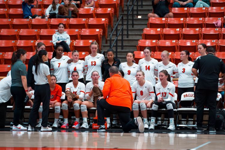 Volleyball team gathers around their coach