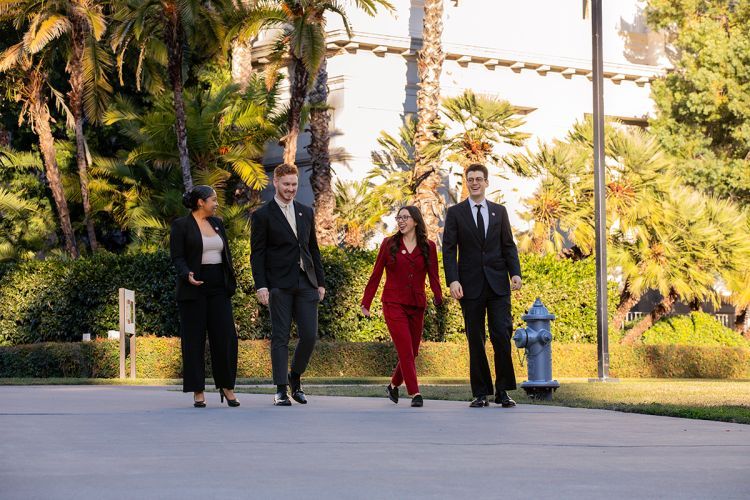 Four students walk by the California State Capitol Building 