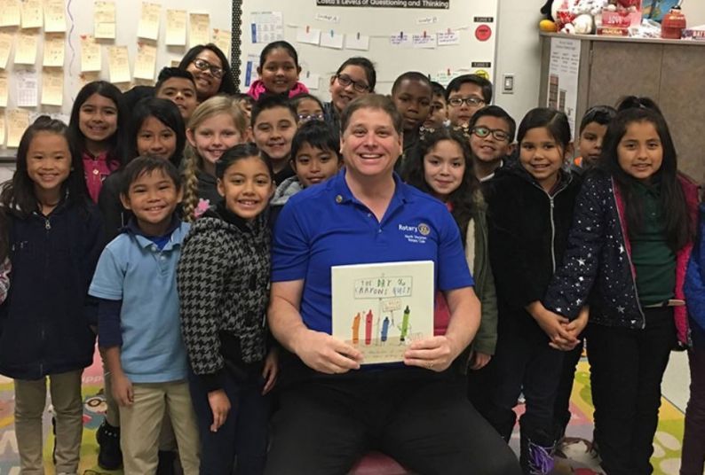 Jim Dugoni, a development officer with Pacific’s Arthur A. Dugoni School of Dentistry, poses with children during the annual Rotary Read-In.