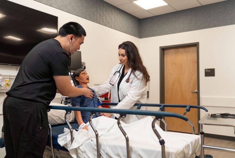 nursing students work with a mannequin in the clinical skills lab