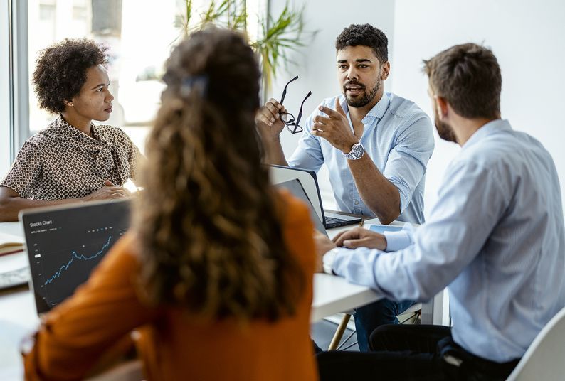 four people sitting at an office table