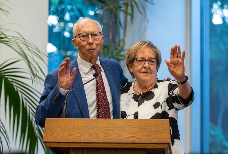 A couple poses for a photo at a podium.