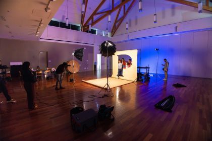 students stand behind a giant letter P during a photo shoot