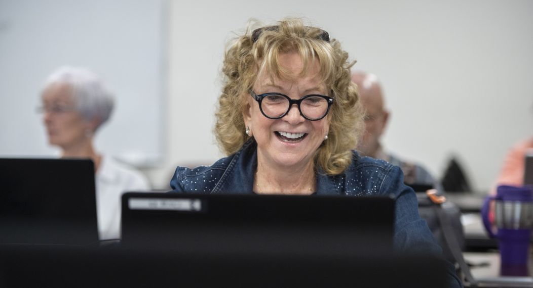 woman smiling and using laptop