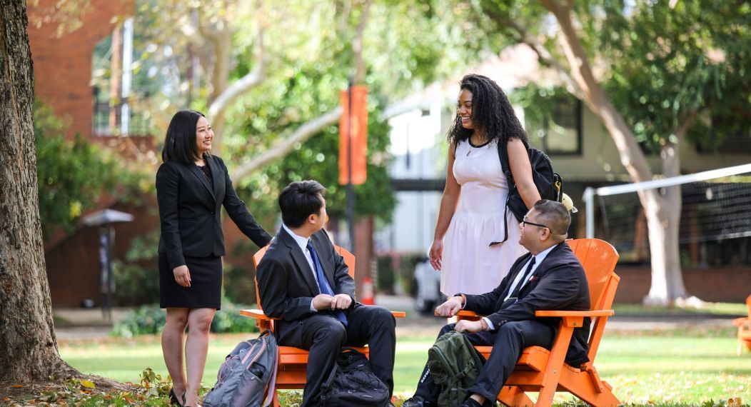 Four students sitting at McGeorge School of Law campus