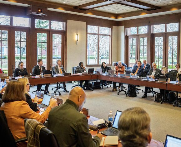 a board of regents meeting taking place in a large room