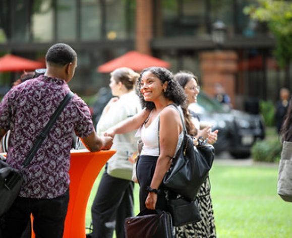 students networking outdoors, shaking hands